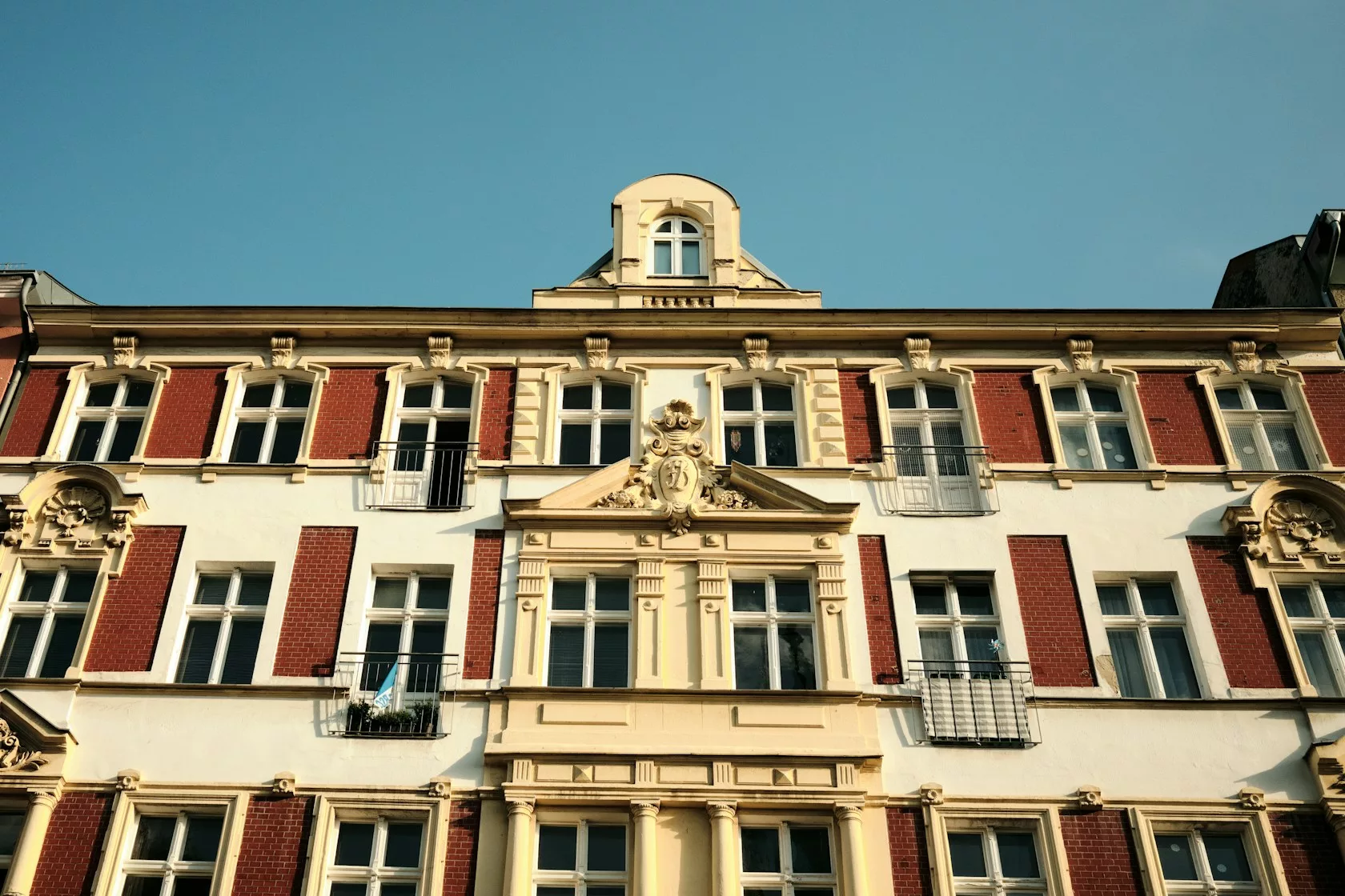 Fachada clásica de un edificio residencial europeo con balcones bajo cielo azul