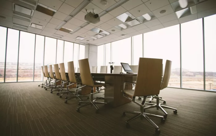Sala de juntas vacía con mesa ovalada de madera y sillas de oficina
